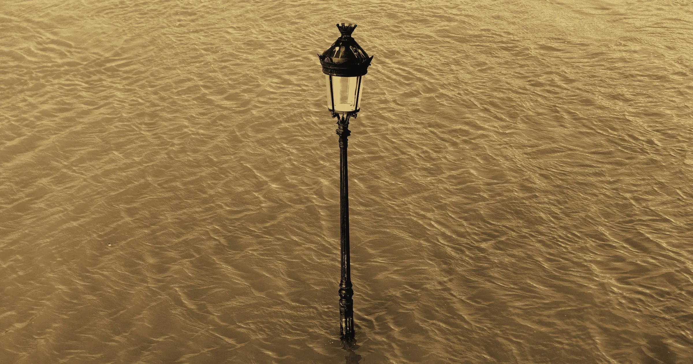 A lone street lamp standing in flood water