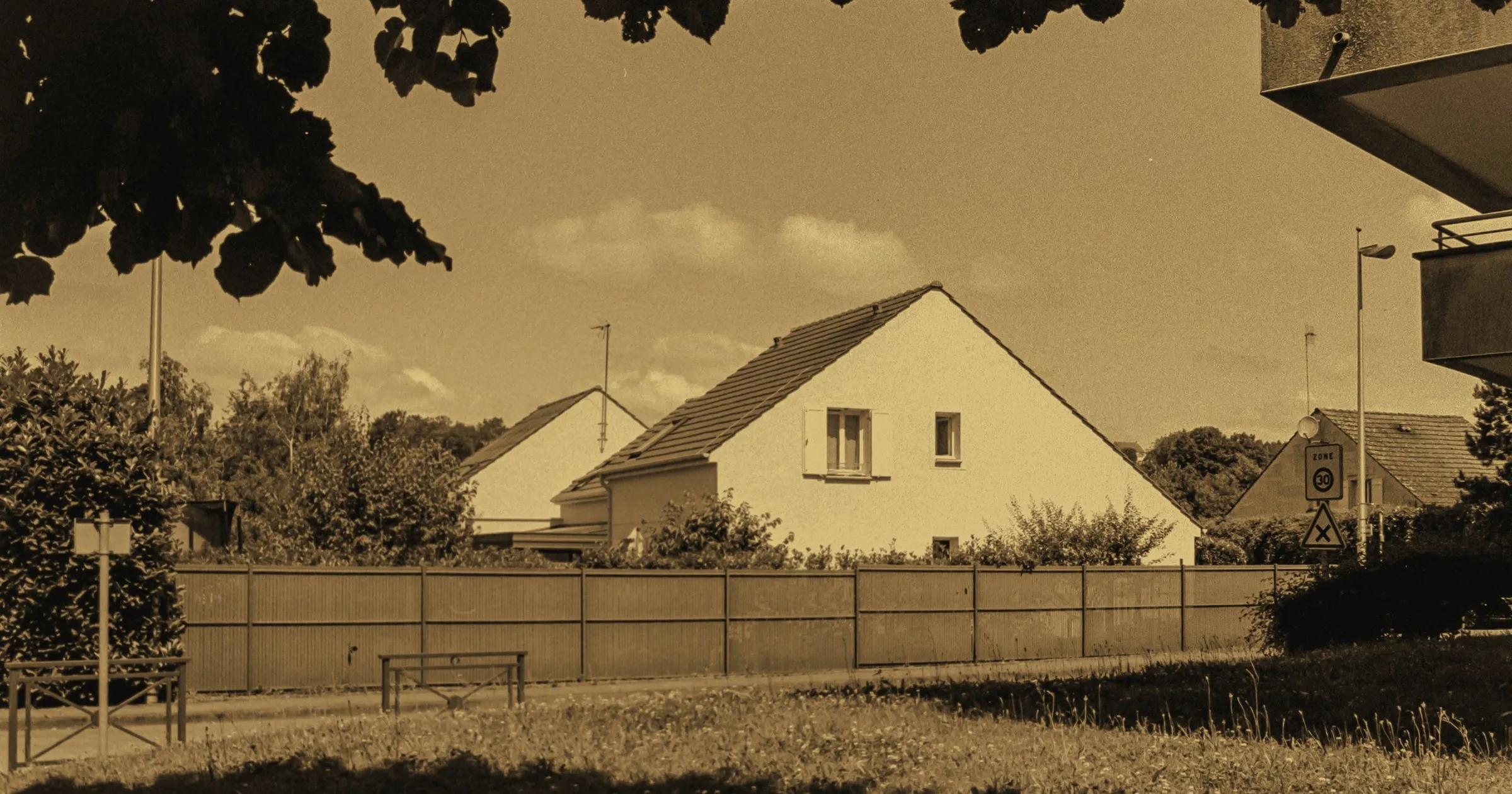 A detached suburban house behind its garden fence