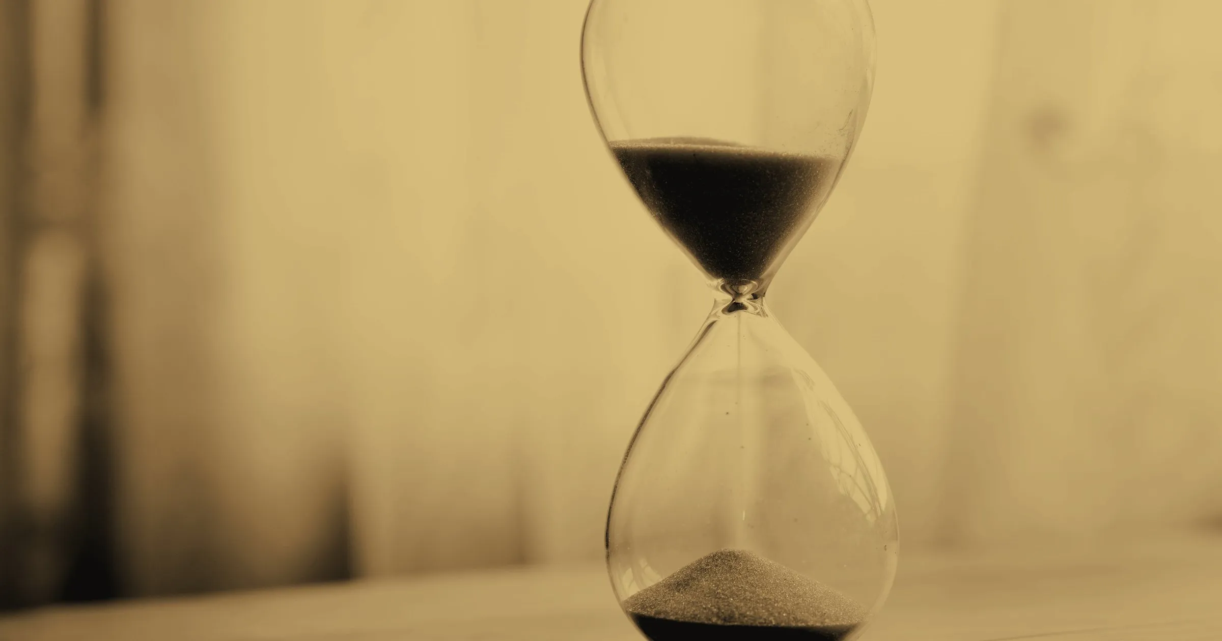 An hourglass with sand running through, in the dark
