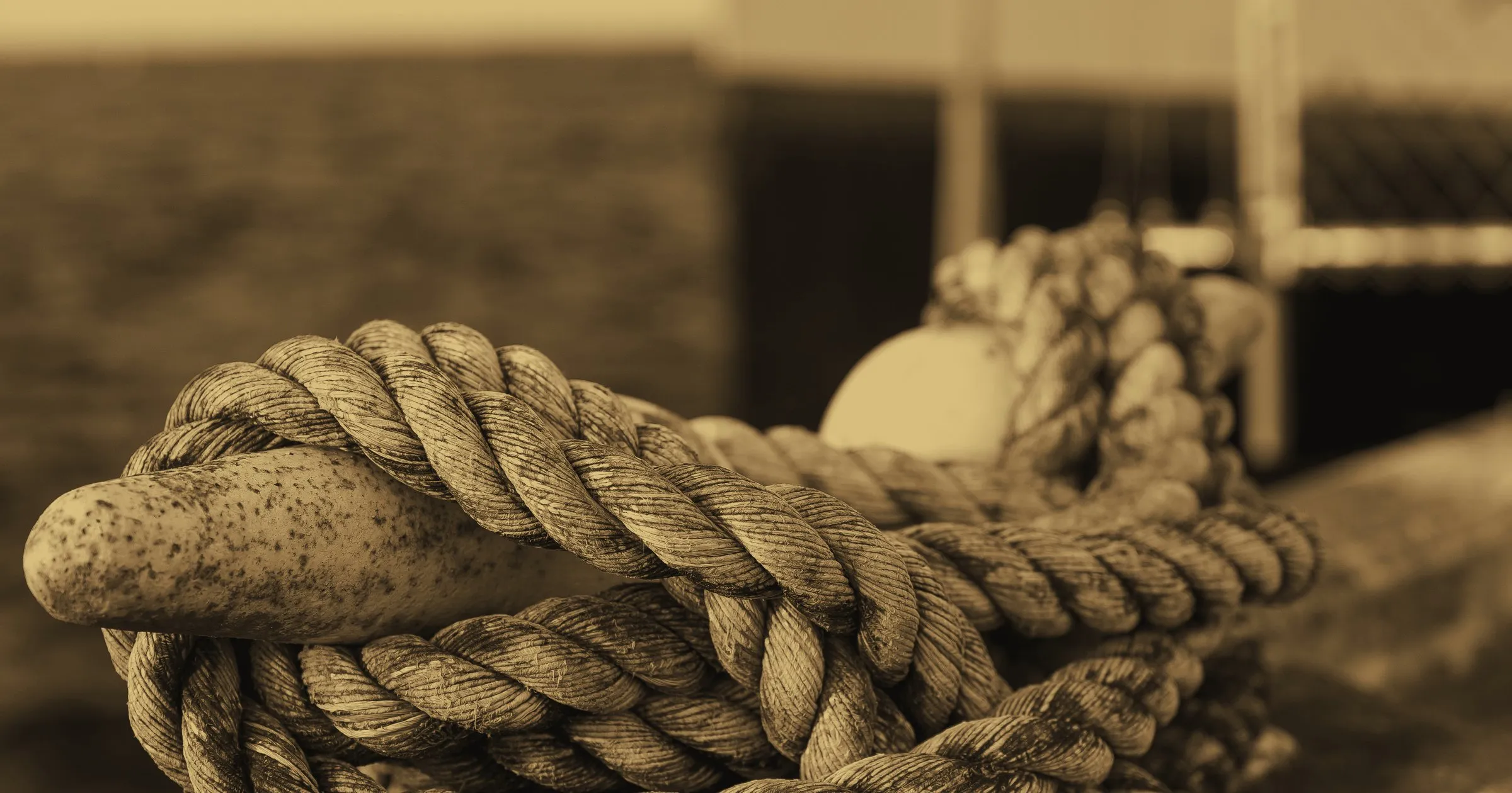 A heavy rope made fast around a cleat on a dock