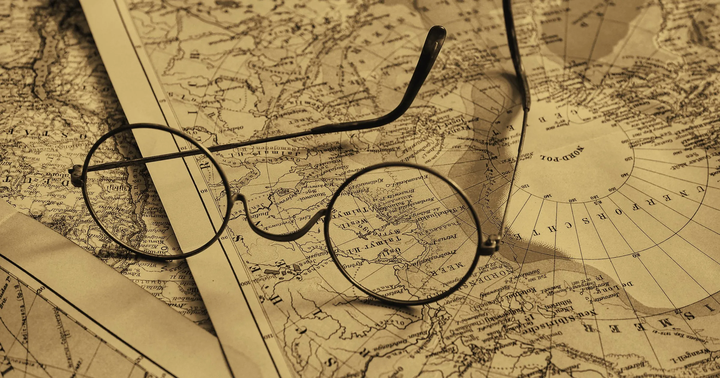 An old map with a pair of spectacles lying on it