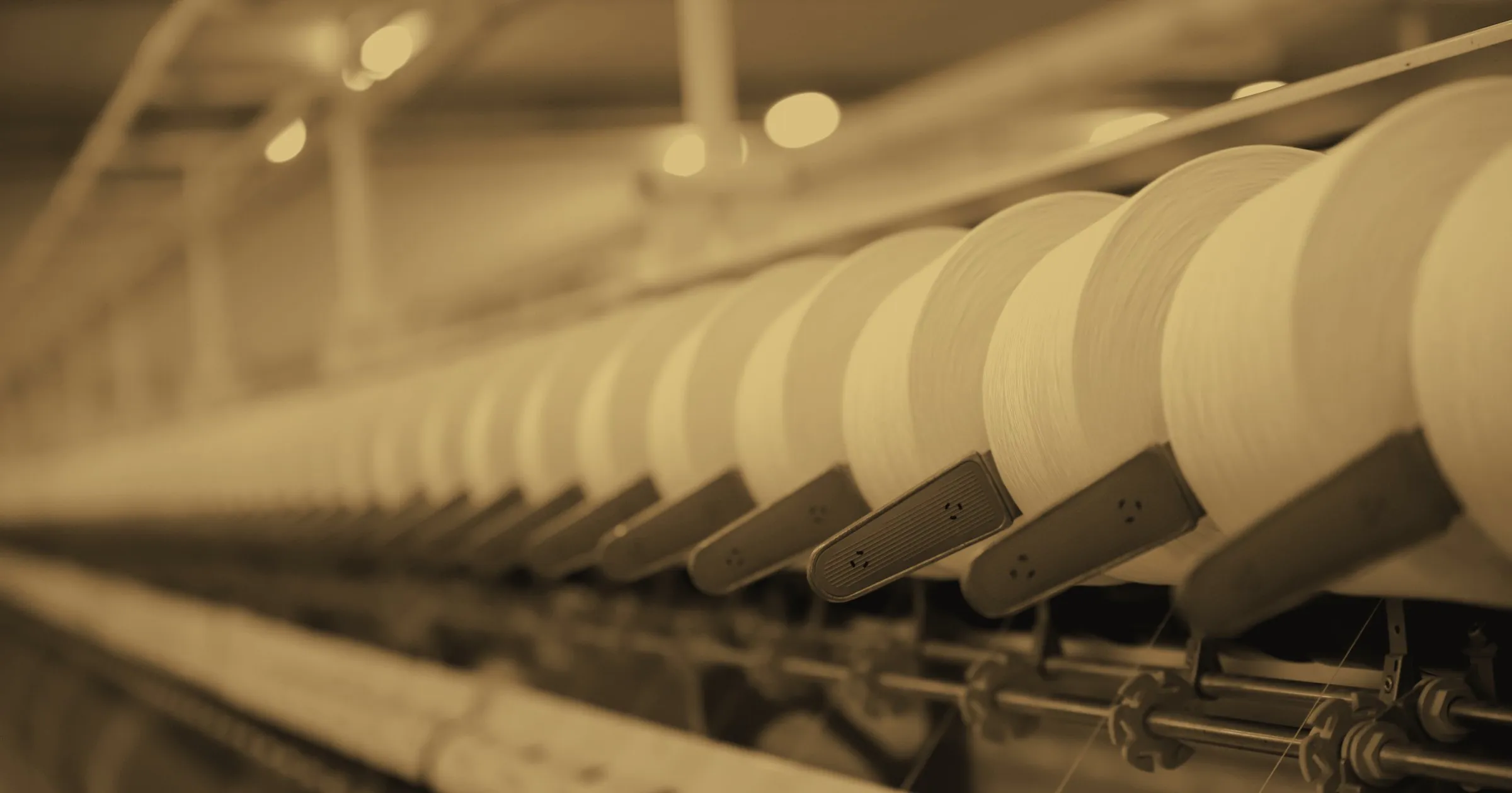 Rows of spinning bobbins on the machinery of a textile mill