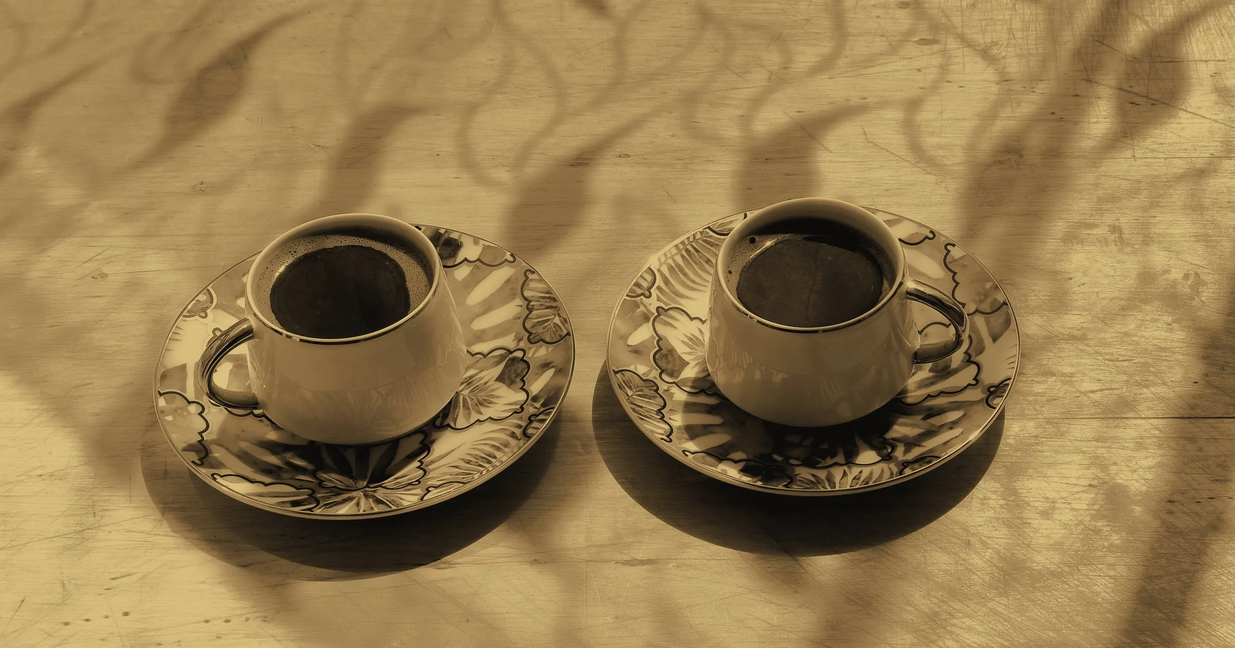 Two cups of coffee on saucers on a kitchen table